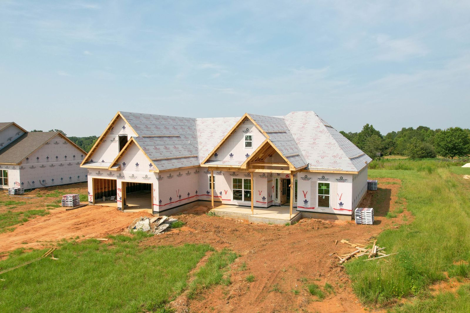 Aerial drone photo of a new home under construction in the Wiregrass, documenting framing and roof progress